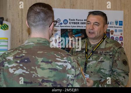 USA Generalmajor Pablo Estrada, Befehlshaber der Task Force 46, spricht mit einem Soldaten vor dem Auditorium einer Cyber-Übung. Vom 8. Bis 10. März 2022 umfasst die Cyber Impact Exercise in Buffalo, New York, über 150 Teilnehmer von 12 Army National Guard, zwei Army Reserve Units sowie lokale, bundesstaatliche, private, akademische, Und kanadischen Partnern. Das 46. Militärpolizeikommando der Michigan National Guard bietet Angehörigen des Verteidigungsministeriums Kommando und Kontrolle, die sich mit zivilen Behörden zusammenschließen und mit ihnen trainieren, um effektiv auf einen schweren Vorfall oder komplexe Katastrophen reagieren zu können Stockfoto