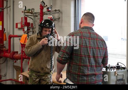 USA Air Force Master Sgt. Kris Harmon, ein Flugzeugtechniker, der dem 180. Kampfflugflügel der Ohio National Guard zugeteilt ist, demonstriert mit dem Combined Air Crew System Tester. Oder BEI einem Besuch mit Kadetten des Reserve Officer Training Corps der Bowling Green State University auf der 180FW in Swanton, Ohio, am 8. März 2022, eine Maschine zur Überprüfung auf Sauerstofflecks während eines Helmmontierens. Die 180FW bot die Gelegenheit, eine einsatzbereite Einheit der Luftwaffe zu sehen und mehr über die Einsatzmöglichkeiten und Fähigkeiten des Flügels zu erfahren, während die Kadetten beginnen, Karrierewege nach dem zu erwägen Stockfoto