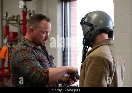 USA Air Force Master Sgt. Kris Harmon, ein Flugzeugtechniker, der dem 180. Kampfflugflügel der Ohio National Guard zugeteilt ist, demonstriert mit dem Combined Air Crew System Tester. Oder BEI einem Besuch mit Kadetten des Reserve Officer Training Corps der Bowling Green State University auf der 180FW in Swanton, Ohio, am 8. März 2022, eine Maschine zur Überprüfung auf Sauerstofflecks während eines Helmmontierens. Die 180FW bot die Gelegenheit, eine einsatzbereite Einheit der Luftwaffe zu sehen und mehr über die Einsatzmöglichkeiten und Fähigkeiten des Flügels zu erfahren, während die Kadetten beginnen, Karrierewege nach dem zu erwägen Stockfoto