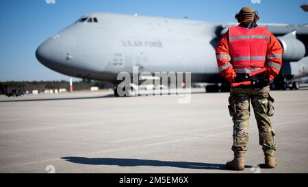 USA Air Force Senior Airman Dakota Woods, 726. Air Mobility Squadron Aircraft Electrical and Environmental Systems Journeyman, bereitet sich auf den Marshal eines U.S. vor Air Force C-5M Super Galaxy Aircraft am Luftwaffenstützpunkt Spangdahlem, Deutschland, 7. März 2022. Eine C-5M Super Galaxy kann 140 Tonnen Material zur Unterstützung von US- und NATO-Operationen liefern. Stockfoto