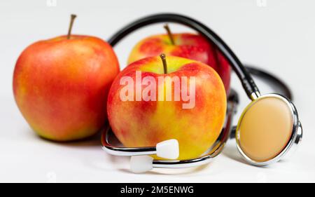 Stethoskop und Äpfel auf weißem Hintergrund Stockfoto
