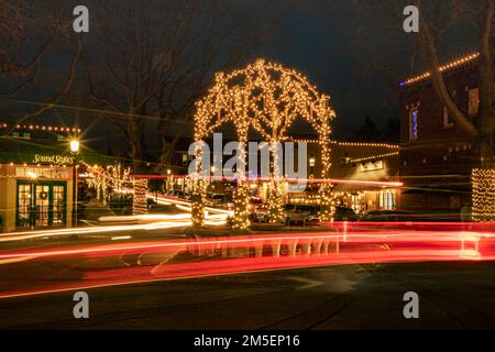 WA22902-00... WASHINGTON - Autos, die an einem Winterabend im Zentrum von Downtown Edmonds in Snohomish County um den Kreisverkehr fahren. Stockfoto