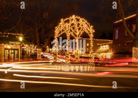 WA22903-00... WASHINGTON - Autos, die an einem Winterabend im Zentrum von Downtown Edmonds in Snohomish County um den Kreisverkehr fahren. Stockfoto