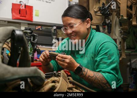 PHILIPPINE SEA (9. März 2022) Aircrew Survival Equipmentman 3. Class Morgan Glazer aus Baltimore, zugewiesen an die ‚Chargers‘ des Helicopter Sea Combat Squadron (HSC) 14, inspiziert eine Pilotenweste an Bord des Flugzeugträgers USS Abraham Lincoln (CVN 72) der Nimitz-Klasse. Die Abraham Lincoln Strike Group befindet sich in einem geplanten Einsatz im US-7.-Flottenbereich, um die Interoperabilität durch Allianzen und Partnerschaften zu verbessern und gleichzeitig als einsatzbereite Truppe zur Unterstützung einer freien und offenen Region Indo-Pacific zu fungieren. Stockfoto