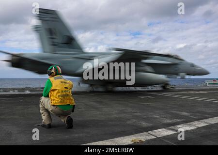 PHILIPPINE SEA (9. März 2022) Chief Aviation Boatswain’s Mate (Equipment) Dustin Nichols aus Commerce, Georgia, signalisiert ein F/A-18E Super Hornet, das den „Tophatters“ der Strike Fighter Squadron (VFA) 14 auf dem Cockpit des Flugzeugträgers der Nimitz-Klasse USS Abraham Lincoln (CVN 72) zugewiesen wurde. Die Abraham Lincoln Strike Group befindet sich in einem geplanten Einsatz im US-7.-Flottenbereich, um die Interoperabilität durch Allianzen und Partnerschaften zu verbessern und gleichzeitig als einsatzbereite Truppe zur Unterstützung einer freien und offenen Region Indo-Pacific zu fungieren. Stockfoto