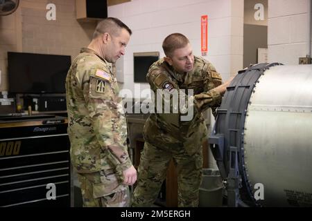 USA Armeebrig. General Justin L. Mann, Leiter des Stabes der Indiana National Guard and Air Force Senior Master Sgt. Mark F. Grabner, Aircraft Armament Systems Flight Chief, sehen Sie sich die Teile einer GAU-8 Avenger 30 mm Kanone an, die in Dem Flugzeug A-10 Thunderbolt II verwendet wird 9. März 2022, Im 122. Kampfflügel, Fort Wayne, Indiana. Mann besichtigte die Waffenfabrik der Flugzeuge, um die Einsatzbereitschaft im 122. Kampfflügel sicherzustellen. Stockfoto