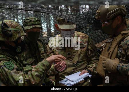 USA Marines mit 31. Marine Expeditionary Unit (MEU) und japanische Soldaten mit dem Amphibious Rapid Deployment Regiment 1. koordinieren die Bewegungen der Einheiten während einer kleinen Manöverübung im Combined Arms Training Center Camp Fuji, Japan, März. 9, 2022. Das kleine Manöver umfasste mehrere Einheiten, die die Positionen anderer Einheiten durchquerten, während sie sich auf ein Ziel zubewegten. Diese Aktionen sind die komplexesten Entwicklungen, die eine partnerschaftliche Truppe durchführen kann. Die Übung zur maritimen Verteidigung Amphibienbrigade ist eine bilaterale Übung, die darauf abzielt, die Interoperabilität zu erhöhen und die Verbindungen zwischen ihnen zu stärken Stockfoto