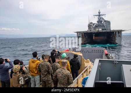 NUMAZU BEACH, Japan (9. März 2022) USA Marines, Mitglieder der japanischen Selbstverteidigungskräfte und Anführer der Numazu-Gemeinde fahren mit einem Landungsschiff zum nach vorn eingesetzten Amphibiendock-Landungsschiff USS Ashland (LSD 48). Ashland, Teil der America Amphibious Ready Group, ist zusammen mit der 31. Marine Expeditionary Unit im Zuständigkeitsbereich der US-amerikanischen 7.-Flotte tätig, um die Interoperabilität mit Verbündeten und Partnern zu verbessern, und dient als einsatzbereite Eingreiftruppe zur Verteidigung von Frieden und Stabilität in der Region Indo-Pazifik. Stockfoto