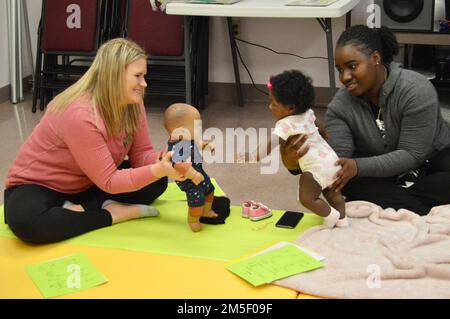 Heather Hoosier (links), lizenzierte klinische Sozialarbeiterin, mit dem New Parent Support Program interagiert mit SPC. Jakel McClain, 317. Ingenieurbataillon, 3. Brigade Combat Team, 10. Mountain Division (Leichte Infanterie) und ihre Tochter Ne'vaeh kürzer (4 Monate) Während einer Säuglingsmassage am 9. März im Joint Readiness Training Center und Fort Polk, Louisiana. Stockfoto