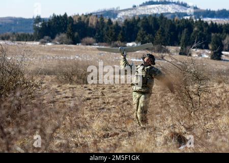 Kevin Brotons, ein Kavallerie-Späher, dem 2. Bataillon zugeteilt, 34. Panzerregiment, 1. Panzerbrigade-Kampfteam, 1. Infanteriedivision, startet einen AeroVironment RQ-11 Raven während des Schaberstreiks 22 im Militärgebiet Hradiště, Nordwesten Tschechiens, 09. März 2022. Stockfoto