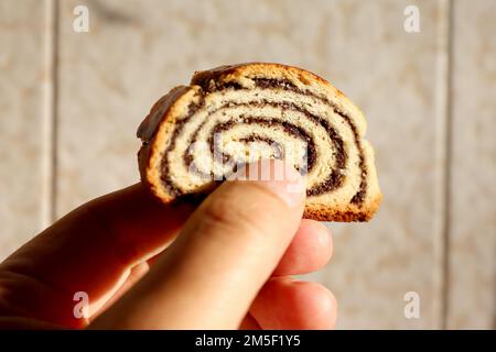 Nahaufnahme eines in Scheiben geschnittenen ungarischen gefüllten gerollten Mohnsamen weihnachtskuchen mit dem Namen Beigli oder Bejgli Stockfoto
