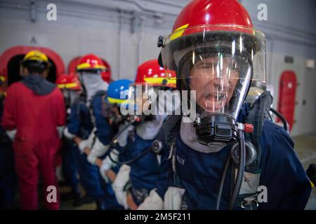 Die Rekruten kommunizieren während einer Übung zur Brandbekämpfung innerhalb des USS Chief Fire Fighter Trainer beim Recruit Training Command. Mehr als 40.000 Rekruten trainieren jährlich im einzigen Boot-Camp der Marine. Stockfoto