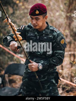 Ein Soldat der Royal Thai Army Special Forces unterrichtet die USA Armeesoldaten, der Braves Company zugeteilt, 4. Bataillon, 23. Infanterie-Regiment, 2. Brigade-Kampfteam, 2. Infanterie-Division, wie man wildes Huhn als Teil eines Dschungel-Skills-Kurses während Hanuman Guardian 2022 in Lopburi, Königreich Thailand, 11. März 2022 zubereitet. Das HG 22 bietet den Vereinigten Staaten und der RTA die Möglichkeit, die Interoperabilität zu verbessern und die Partnerkapazitäten bei der Planung und Durchführung komplexer und realistischer Operationen der multinationalen Truppe und der kombinierten Task Force zu erhöhen. Stockfoto