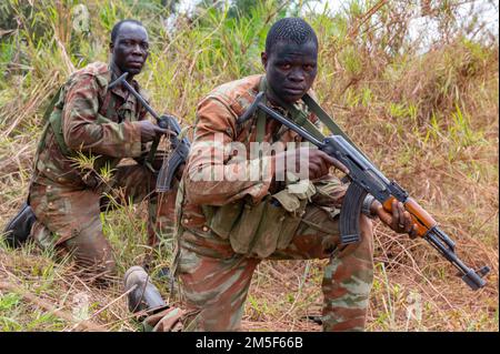 Soldaten des 1. Kommando-Parachutentataillons bereiten sich auf die Überquerung einer linearen Gefahrenzone vor, während eines simulierten Hinterhalt-Trainings in Ouassa, Benin, 11. März 2022. Unser Engagement ist ein kleiner Beitrag, um unseren Partnern dabei zu helfen, ihre Bevölkerung zu schützen und die globale Bedrohung durch gewalttätigen Extremismus zu bekämpfen. Stockfoto