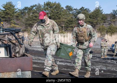 Tech Sgt. Ja Lee, 374. Sicherheitstrupp-Geschwader für Rüstungsausbildung und -Wartung (links), Und Airman 1. Klasse Cylas Zubyk, 374. SFS Patrolman (rechts), transportieren Munition zu den Waffen, die vor einer M240- und M249-Maschinengewehrqualifizierung im Combined Arms Training Center Camp Fuji, Japan, am 10. März 2022 eingerichtet wurden. CATM-Ausbilder Schulen Flugzeuge in der richtigen Etikette für Gewehre, Sicherheitsverfahren und dem effizienten Schusswaffenabfeuern. Stockfoto