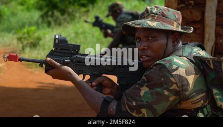 Tansania People’s Defense Force (TPDF) und Marine Special Forces (MSF) führen einen simulierten Angriff durch, während die USA Army Green Beret, der 3. Special Forces Group zugewiesen, beaufsichtigt während einer gemeinsamen kombinierten Austauschschulung (JCET) in der Nähe von mSATA, Tansania, 10. März 2022. Die Teams konzentrierten sich auf die Vertiefung grundlegender Fähigkeiten wie grundlegende Schießkunst, Taktik kleiner Einheiten und Missionsplanung. Stockfoto