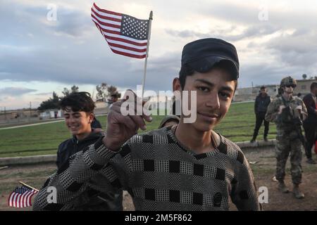 Ein Einheimischer in einem kleinen Dorf hält am 10. März 2022 die amerikanische Flagge im Nordosten Syriens. Gemeinsame Task Force - Operation inhärente Entschlossenheit berät, unterstützt und befähigt die Partnerkräfte in den ausgewiesenen Gebieten Syriens weiterhin, die Voraussetzungen für langfristige Sicherheit zu schaffen. Stockfoto