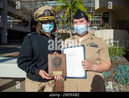 220311-N-XB470-1013 SAN DIEGO (11. März 2022) Captain Kim Davis, Navy Medicine Readiness and Training Command (NMRTC) San Diego's Commanding Officer (Left), verleiht Hospital Corpsman 2. Class Samantha Pariseau, eine Matrose, die der NMRTC San Diego (rechts) zugeteilt wurde, mit einem Empfehlungsschreiben während einer Preisverleihung im Krankenhaus am 11. März. Pariseau erhielt von Oktober 2021 bis Dezember 2021 das Commendation Letter für ihre herausragende Erfüllung ihrer Aufgaben als Work Center Supervisor. Die Mission von NMRTC San Diego ist es, die Servicemitglieder auf den Einsatz zur Unterstützung der operativen FO vorzubereiten Stockfoto