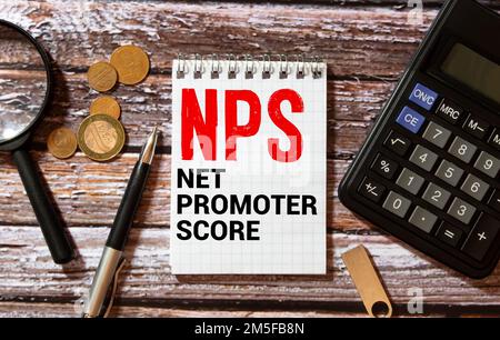 In einem handgefertigten farbigen Notizbuch befindet sich neben Bleistiften, Brillen, Grafiken und Diagrammen eine NPS NET PROMOTER-PUNKTEAUFSCHRIFT. Stockfoto