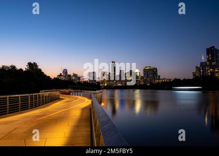 Eine lange Aufnahme der Skyline von TX bei Sonnenuntergang von der Promenade rund um den Town Lake in Austin Stockfoto