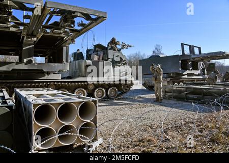 USA 41. Artilleriebrigade zugeteilte Soldaten beladen M270 Raketensysteme für eine Feuerübung im Grafenwoehr-Trainingsbereich des 7. Armeeübungskommandos, Deutschland, 11. März 2022. Die Stationierung der US-Streitkräfte hier ist eine umsichtige Maßnahme, die die kollektiven Ziele der NATO zur Kriegsprävention, die Verteidigungsorientierung und das Engagement zum Schutz aller Alliierten untermauert. Stockfoto