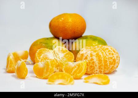 Mehrere Tangerinen und mehrere Birnen auf einem weißen Teller Stockfoto
