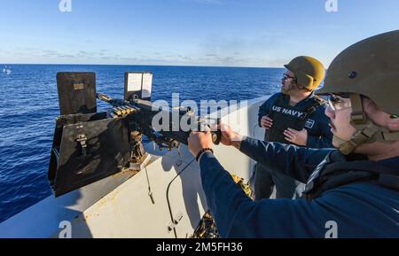 PACIFIC OCEAN (12. März 2022) Fire Controlman 2. Class Andrew Yu aus Las Vegas feuert ein Maschinengewehr Kaliber .50 ab, während Gunner's Mate 1. Class Casey Acosta aus Oak Hills, Kalifornien, während einer Feuerübung an Bord des Amphibienschiffs USS John P. Murtha (LPD 26) beobachtet, März 12. John P. Murtha führt gerade Routineeinsätze in der US-3.-Flotte durch. Stockfoto