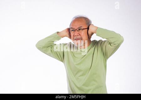 Porträt eines älteren Mannes mit Brille, traurig, der die Ohren mit Fingern bedeckt Stockfoto