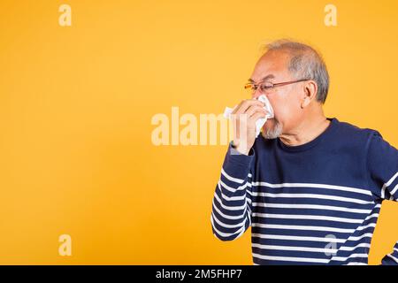 Asiatischer älterer Mann Erkältung hat Grippe und Niesen von Krankheit Virus Problem verwenden Gewebe Stockfoto