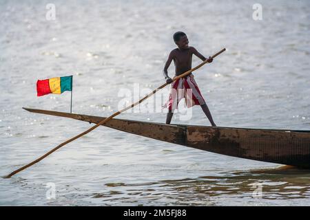 Ein Pirogen mit der Nationalflagge von mali und Kind in Mopti, Mali, Westafrika. Stockfoto