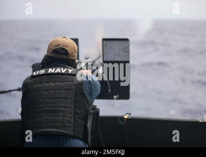 PHILIPPINE SEA (12. März 2022) Gunner's Mate 2. Klasse Devon Armstrong feuert 50 Kal. ab. Maschinengewehr während einer Schießübung an Bord des Arleigh-Burke-Klasse-geführten Raketenzerstörers USS Higgins (DDG 76). Higgins ist dem Befehlshaber der Task Force (CTF) 71/Destroyer Squadron (DESRON) 15, der größten nach vorn eingesetzten DESRON der Marine und der Hauptstreitkräfte der US-7.-Flotte zugewiesen. Stockfoto