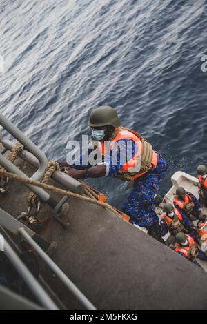 ATLANTIK (13. März 2022) Ein Seemann mit dem Militär Gambias geht an Bord der Expeditionären Seebasis USS Hershel ‚Woody‘ Williams (ESB 4), als Teil einer Trainingsentwicklung während der Übung Obangame Express 2022, 13. März 2022. Obangame Express 2022, durchgeführt von U.S. Forces Africa ist eine maritime Übung auf See, die darauf abzielt, die Zusammenarbeit zwischen den teilnehmenden Nationen zu verbessern, um die Sicherheit und Gefahrenabwehr im Seeverkehr im Golf von Guinea und in den westafrikanischen Küstenregionen zu erhöhen. Stockfoto