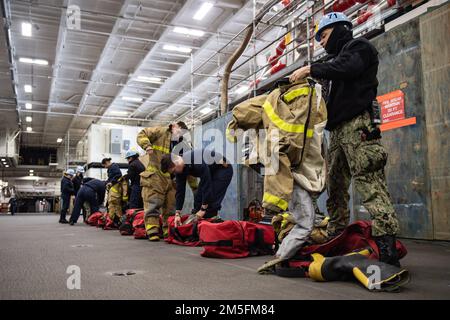 MARINESTÜTZPUNKT KITSAP-BREMERTON, WASHINGTON (13. März 2022) – USA Navy Sailers legen während eines Damage Control Rodeos an Bord des Flugzeugträgers USS Theodore Roosevelt (CVN 71) der Nimitz-Klasse am 13. März 2022 Feuerlöschausrüstung an. Theodore Roosevelt unterzieht sich einer geplanten zusätzlichen Anlegephase an der Puget Sound Naval Shipyard und der Intermediate Maintenance Facility, wo das Schiff planmäßig gewartet und modernisiert wird. Stockfoto