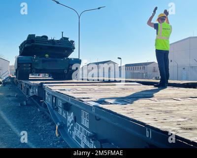 Ein Auftragnehmer, der zur Unterstützung der 405. Army Field Support Brigade eingesetzt wurde, leitet einen M1A2 Abrams Hauptkampfpanzer bei der Verladung auf einen deutschen Eisenbahnwaggon am Coleman-Arbeitsplatz in Mannheim. Die 405. AFSB hat vor Kurzem damit begonnen, ihre Transporter für Schwermaschinen für den Streckentransport von Armeevorräten-2-Ausrüstung von Coleman zum Trainingsgebiet Grafenwoehr mit der Deutschen Bahn (Deutsche Bahn) zu erweitern. Mehr als zwei Dutzend gepanzerte Fahrzeuge und Ausrüstungsteile – von Panzern über selbstfahrende Paladin-Haubitzen bis hin zu Kampffahrzeugen von Bradley und mehr – wurden über die Schiene Ma transportiert Stockfoto