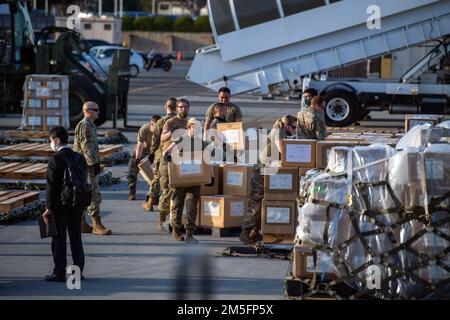 USA Air Force Airmen vom 730. Air Mobility Squadron, der 515. Air Mobility Operations Group und Soldaten der Japan Ground Self-Defense Force entladen und sortieren humanitäre Hilfsgüter der japanischen Regierung auf Luftfrachtpaletten am Yokota Air Base, Japan, 14. März 2022. Die japanische Regierung stellte der Ukraine 38 Tonnen humanitärer Hilfsgüter zur Verfügung und arbeitete mit den USA zusammen Air Force Airmen vom 730. Air Mobility Squadron und der 515. Air Mobility Operations Group liefern, verpacken und bereiten Luftfracht vor. Stockfoto