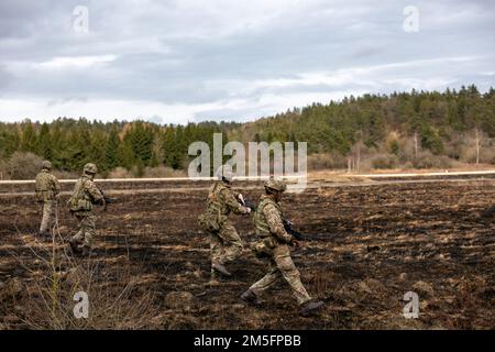 Eine Truppe britischer Offiziersadetten der Royal Military Academy Sandhurst beginnt eine taktische Feuerübung auf dem Grafenwoehr-Trainingsgelände des US 7. Army Training Command, Grafenwoehr, Deutschland, 14. März 2022. Stockfoto