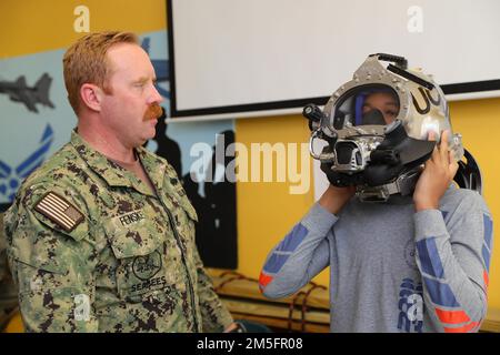 Baumechaniker Steve Fenske, Klasse 2. aus Castaic, Kalifornien, dem Underwater Construction Team 1 (UCT 1) zugewiesen, weist einen Studenten der New Hampstead High School (NHHS) an, während eines Besuchs der Savannah Navy Week am 14. März 2022 einen VON der Oberfläche bereitgestellten TAUCHHELM MIT KM 97 anzuprobieren. Matrosen von UCT 1 und das Fleet Outreach Ambassador Team besuchten NHHS, um ihre Erfahrungen und Geschichten auszutauschen, damit Schüler die Marine und ihre Rolle in der nationalen Sicherheit besser verstehen. Stockfoto