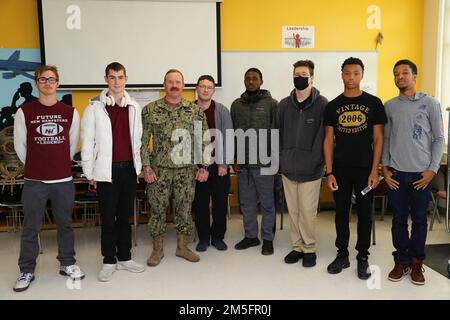 Baumechaniker Steve Fenske, Klasse 2., aus Castaic, Kalifornien, dem Underwater Construction Team 1 (UCT 1) zugewiesen, posiert für ein Gruppenfoto mit Studenten der New Hampstead High School (NHHS) während eines Besuchs der Savannah Navy Week am 14. März 2022. Matrosen von UCT 1 und das Fleet Outreach Ambassador Team besuchten NHHS, um ihre Erfahrungen und Geschichten auszutauschen, damit Schüler die Marine und ihre Rolle in der nationalen Sicherheit besser verstehen. Stockfoto