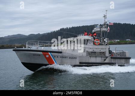 Die Besatzung an Bord eines 47-Fuß-Motorrettungsboots von der Coast Guard Station Umpqua River wird hier am 14. März 2022 durch den Umpqua River in Winchester Bay, Oregon, geführt. Das 47-Fuß-Motorrettungsboot wurde als schnell reagierendes Rettungsschiff auf hoher See, im Surfen und bei schwerem Wetter entwickelt. Stockfoto