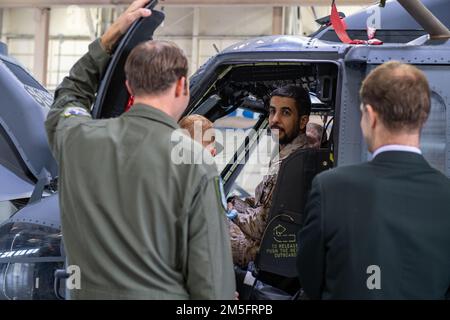 Ein Mitglied der Royal Saudi Air Force sitzt im Cockpit eines HH-60W Jolly Green II und spricht mit einem US-amerikanischen Mitglied Air Force Pilot vom 41. Rettungsgeschwader am Luftwaffenstützpunkt Moody, Georgia, 14. März 2022. Die RSAF besuchte mehrere Orte und erfuhr etwas über die Fähigkeiten der HH-60W Jolly Green II und die Kampfsuche und -Rettungsmission. Stockfoto