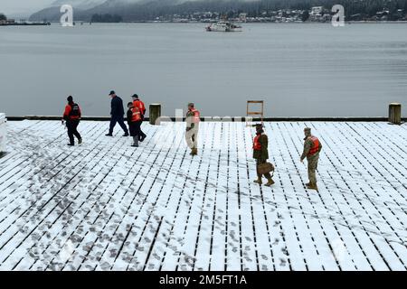 Leitende Führungskräfte, die Training ARCTIC EDGE 2022 unterstützen, gehen während ihres Besuchs in den USA über den Pier Küstenwache Juneau, Alaska, 15. März 2022. Während des angesehenen Besuchertages hatte das Personal die Gelegenheit, sich auf eine US-amerikanische Reise zu begeben Kleines Boot der Küstenwache zur Tour Coast Guard Cutter John McCormick. AE22 umfasste etwa 1.000 Teilnehmer, darunter US-amerikanische und kanadische Servicemusiker Küstenwache und Regierungsangestellte aus den USA Verteidigungsministerium und kanadisches Verteidigungsministerium. Stockfoto