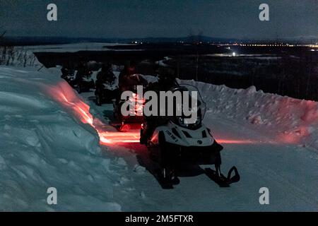 Soldaten der US-Spezialeinheiten und Mitglieder des 3. Bataillons, Royal 22e Régiment Canadian Army, führen Nachtoperationen auf Schneemobilen im Donnelly Training Area in Fort Greely, AK, während der Übung Joint Pacific Multinational Readiness Center am 22-02. März 16, 2022 durch. JPMRC 22-02 ist auf gemeinsame und multinationale Partner angewiesen, um erfolgreich zu sein. Dazu gehören mehrere unterstützende Einheiten der US- und kanadischen Armee sowie Luft- und Bodenpersonal der US- und kanadischen Luftwaffe (Canadian Forces Combat Camera/Master Sailor Dan Bard). Stockfoto