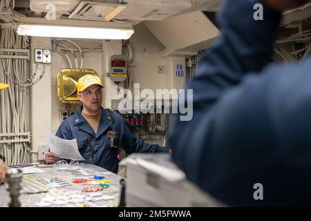 NEWPORT NEWS, VA (15. März 2022) – Chief Aviation Boatswain’s Mate (Handling) (AW/SW) Carmine A. Bosco, aus South Point, Ohio, an Bord des Flugzeugträgers USS George Washington der Nimitz-Klasse (CVN 73) der Abteilung Air zugewiesen, Eine Nachbesprechung des Schulungsteams zur Kontrolle der Schäden im Cockpit nach einer allgemeinen Quartierübung, während das Schiff eine simulierte Übung auf See durchführt. George Washington wird bei Newport News Shipyard den Tankkomplex überholen (RCOH). RCOH ist ein mehrjähriges Projekt, das nur einmal während der 50-jährigen Lebensdauer eines Frachtführers durchgeführt wird und das Betanken des Schiffes einschließt.“ Stockfoto