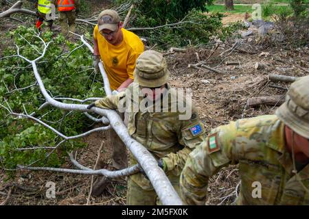 BRISBANE, Australien (15. März 2022) – Machinist’s Mate (Nuklear) 1. Klasse Joshua Thomas, dem Emory S. Land-Class-U-Boot-Tender USS Frank Cable (AS 40) und Mitgliedern des australischen Militärs Clear Flood Assist, März 15. Das Gebiet von Brisbane erlitt von Ende Februar bis Anfang März schwere Überschwemmungen. Matrosen und Militär-Sealift-Kommando-Seeleute arbeiten Seite an Seite mit der australischen Verteidigungskräfte, um Trümmer aus den betroffenen Gebieten um Brisbane zu entfernen. Frank Cable ist auf Patrouille und führt expeditionäre Wartung und Logistik in en durch Stockfoto