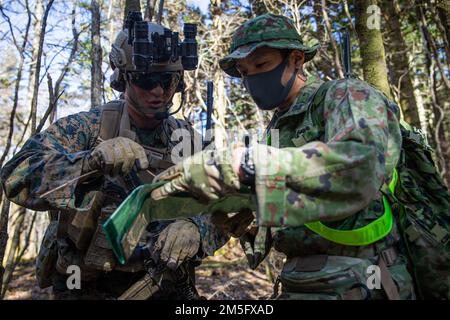 EIN US-AMERIKANISCHER Marine mit Bataillon Landing Team 1/5, 31. Marine Expeditionary, und ein Soldat mit dem Amphibious Rapid Disposement Regiment 1., japanische Boden-Selbstverteidigungseinheit, diskutieren Kartengelände während einer Hubschrauberrazzia Training Übung im Combined Arms Training Center Camp Fuji, Japan, 15. März 2022. Die Übung wurde durchgeführt, um Kenntnisse in der schnellen Ergreifung und Verteidigung von Schlüsselgelände zu entwickeln. Maritime Defense Übung Amphibious Rapid Deployment Brigade ist eine bilaterale Übung, die die Interoperabilität erhöhen und die Verbindungen zwischen US-amerikanischen und japanischen Streitkräften zur Verteidigung von stärken soll Stockfoto