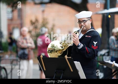 Der Musiker der 2. Klasse Alejandro Mejia aus Miami, der der Navy Band Southeast zugeteilt ist, spielt während der Savannah Navy Week am 15. März 2022 das french Horn auf dem Savannah City Market. Die Navy Week ist eine jährliche Reihe von Veranstaltungen, die das ganze Jahr über in verschiedenen US-amerikanischen Städten stattfinden, in denen die Marine nicht präsent ist. Sie bietet den Bürgern die Möglichkeit, mit Seeleuten zu interagieren und mehr über die Navy und ihre Fähigkeiten zu erfahren. Stockfoto