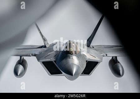 Ein F-22 Raptor, der der Region Alaska NORAD zugeteilt wurde, fliegt hinter einem KC-135R Stratotanker während der Operation ADLIGER VERTEIDIGER über dem Golf von Alaska, 16. März 2022. NOBLE DEFENDER ist ein Luftverteidigungsinstitut des North American Aerospace Defense Command, bei dem US-Streitkräfte mit Sicherheits- und Verteidigungspartnern zusammenarbeiten, um eine integrierte Abschreckung zu gewährleisten und Bedrohungen aus allen Angriffswegen abzuwehren. Stockfoto