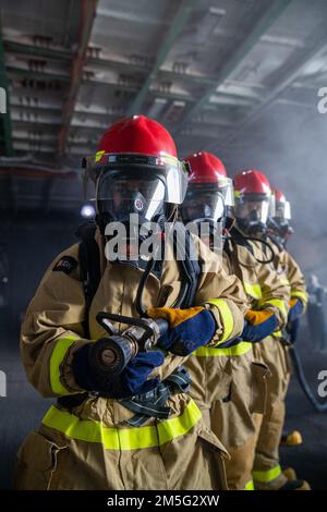 220317-N-UK596-1383 NEWPORT NEWS, VA (17. März 2022) – Matrosen an Bord des Flugzeugträgers USS George Washington (CVN 73) der Nimitz-Klasse bewachen den Schlauch, während das Schiff während einer allgemeinen Quartierübung eine simulierte Übung auf See durchführt. George Washington wird bei Newport News Shipyard den Tankkomplex überholen (RCOH). RCOH ist ein mehrjähriges Projekt, das nur einmal während der 50-jährigen Lebensdauer eines Frachtführers durchgeführt wird und das Betanken der beiden Kernreaktoren des Schiffs sowie umfangreiche Reparaturen, Aufrüstungen und Modernisierungen umfasst. Stockfoto