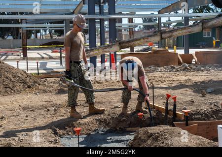 220315-N-MQ841-1099 PORT HUENEME, KALIFORNIEN (15. März 2022) Baumeister Curtis Weymouth (links) und Baumeister Caleb Norris, beide dem Naval Mobile Construction Battalion (NMCB) 5 zugeteilt, betreiben einen Betonvibrator, um den Beton zu konsolidieren, damit Betonfußfüßer während eines technischen Trainers an Bord des Naval Base Ventura County Port Hueneme, Kalifornien platziert werden können. Die USA Navy Seabees mit NMCB-5 werden aus Port Hueneme heimgeschickt. Sie trainieren in hochwertiger Konstruktion, Expeditionslogistik und Kampfbetrieb zur Durchführung von Bau- und Ingenieurprojekten Stockfoto