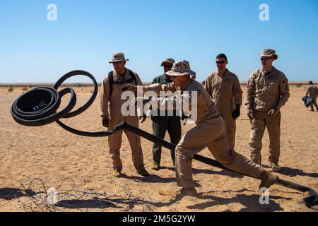 USA Marines, die der Flugzeugstützung, der Marine Aviation Weapons and Tactics Squadron One (MAWTS-1) zugeteilt sind, lösen einen Treibstoffschlauch während einer praktischen Anwendung eines FARP (Front Arrangement and Tanken Point), während des Waffen- und Taktik-Lehrgangs (WTI) 2-22, am Hilfsflugplatz II, nahe Yuma, Arizona, am 16. März 2022. WTI ist eine siebenwöchige Schulungsveranstaltung, die von MAWTS-1 veranstaltet wird und die Standardisierung, fortgeschrittene taktische Ausbildung und Zertifizierung von Ausbildungslehrerqualifikationen für Einheiten zur Unterstützung der Ausbildung und Bereitschaft in der Marine Aviation sowie zur Unterstützung bei der Entwicklung und dem Einsatz von Flugwaffen und -Taktiken bietet. Stockfoto